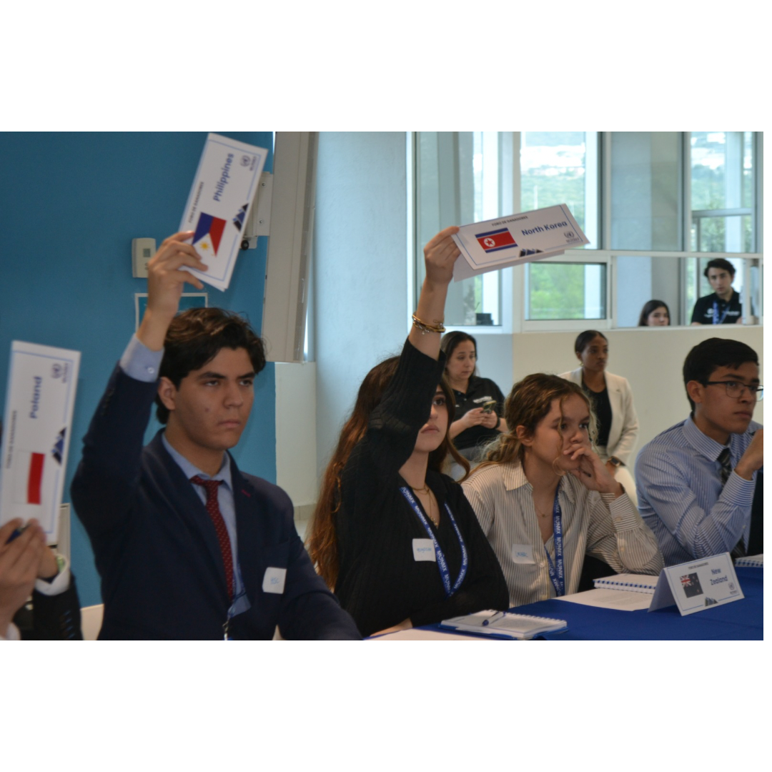MUNMX delegates raising placards during voting session